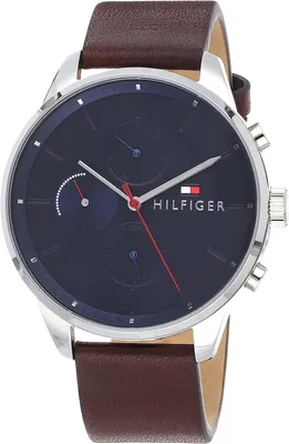 A close-up studio shot of a Tommy Hilfiger watch with a blue dial and a brown leather strap.