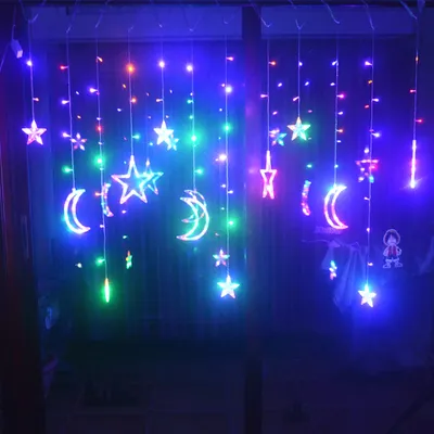 A string of colorful LED lights shaped like stars and moons hanging in front of a dark background.