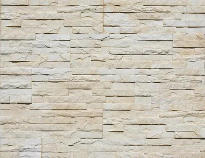 A full-frame shot of a wall covered in stacked stone veneer tiles.