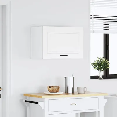 A white kitchen wall with a white cabinet mounted on it. Below the cabinet is a small kitchen cart with a wooden top. A bowl, a pitcher, and a mug are on the cart. A window with blinds is visible to the right.