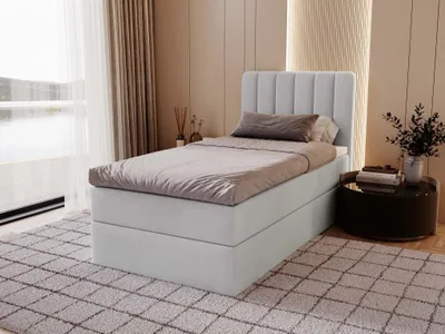 A bedroom scene with a bed, rug, and side table.
