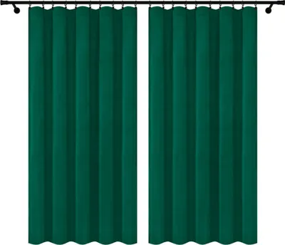 Two dark green velvet curtains hanging from a curtain rod.