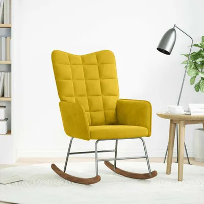 A yellow velvet rocking chair in a room with a bookshelf and a lamp.