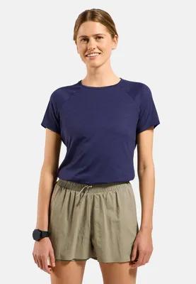 Frau trägt dunkelblaues Odlo Active 365 T-Shirt mit kurzen Ärmeln und beige Shorts mit elastischem Bund und Kordelzug