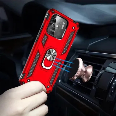 A hand holding a red phone case with a ring holder, attached to a magnetic car mount on an air vent.