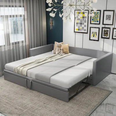 A grey sofa bed is shown in a room with curtains and wall art.