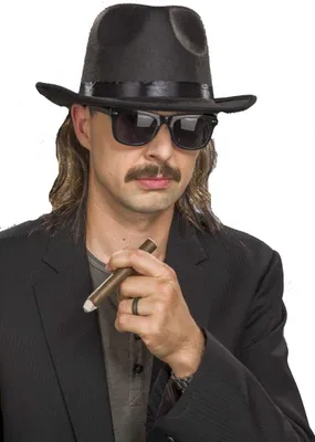 A man wearing a hat, sunglasses, and a suit, holding a cigar.