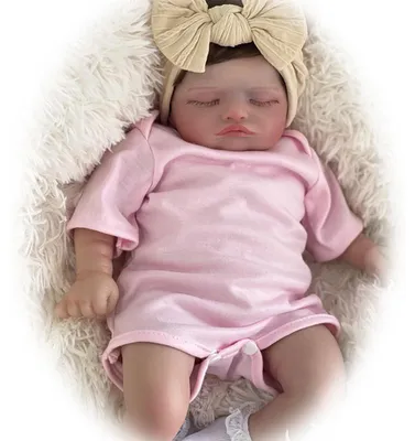 Zdjęcie produktu dla 45 cm, zamknięte oczy, przeszczep włosów, ciało z bawełny, wszczepione rzęsy, różowy kombinezon na krótkie rękawki + białe skarpetki + jasnobeżowa opaska na włosy z kokardką, realistyczna lalka.