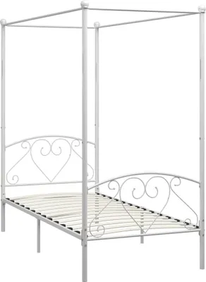 A white metal canopy bed frame with a slatted base and heart-shaped decorative elements on the headboard and footboard, presented against a white background.