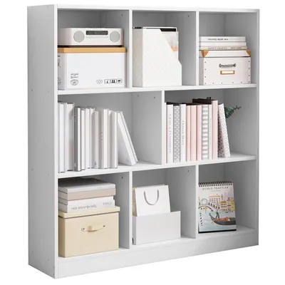 A white, multi-compartment bookshelf filled with various items.