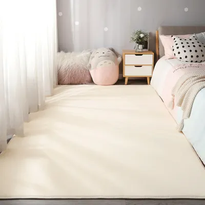 A bedroom scene with a rug, bed, and nightstand.