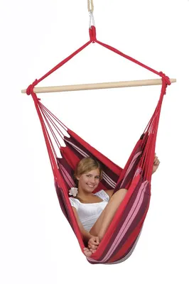 A woman sitting in a striped hammock chair.