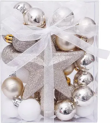A clear, well-lit studio shot of a set of champagne-colored Christmas ornaments and a star, neatly arranged in a transparent box and tied with a white ribbon.