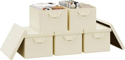 A set of five cream-colored storage boxes, some stacked and some open, with books and other items inside.