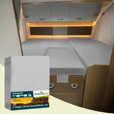 Interior of a camper van with a bed made up with sheets.