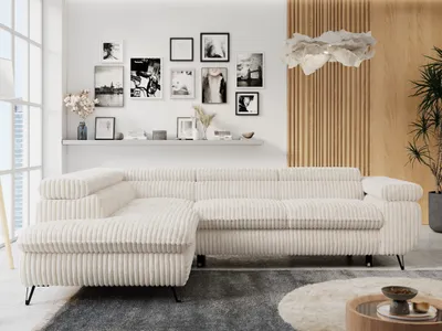 A modern living room with a beige sectional sofa, a shelf with framed pictures, and a decorative light fixture.