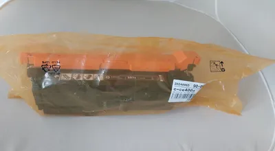 A product inside a plastic bag, likely a toner cartridge.