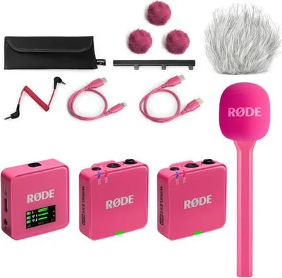 A collection of pink wireless microphones and accessories laid out on a white background.