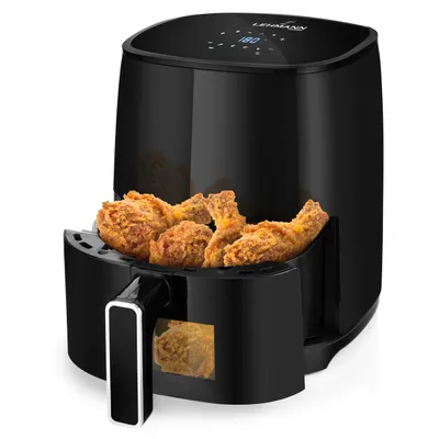 A black air fryer with fried chicken in the basket, against a white background.