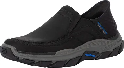 A black Skechers slip-on shoe with a gray sole is shown against a white background.