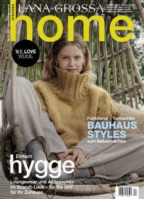 A woman sitting in a hanging chair, wearing a knitted sweater.