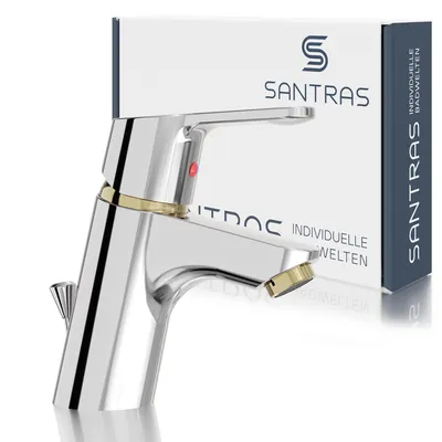 A chrome and gold faucet is shown in front of its packaging.