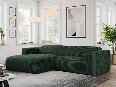 A modern living room with a green corduroy sectional sofa, large windows, and artwork.