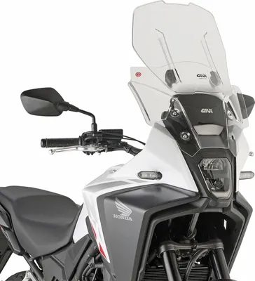 Close-up of the front of a motorcycle, focusing on the windshield and headlight.
