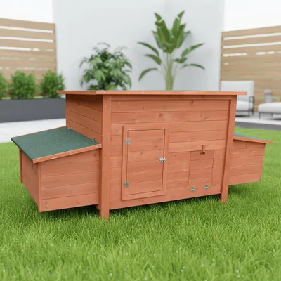 A wooden chicken coop with a green roof sits on a grassy lawn.