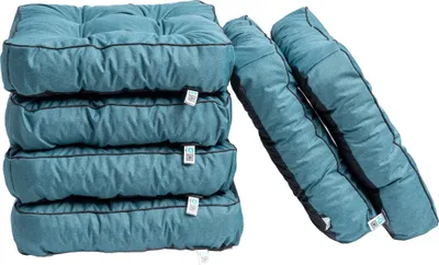 A stack of teal cushions and two leaning teal cushions against a white background.