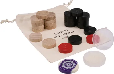 A collection of carrom game pieces, including wooden, black, and red discs, along with a decorative purple and white striker, are arranged on a beige drawstring bag.