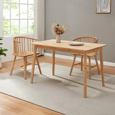 A dining table and chairs set in a room with a window and a rug.