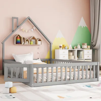 A child's bed with a house-shaped frame, decorated with a mountain mural on the wall.