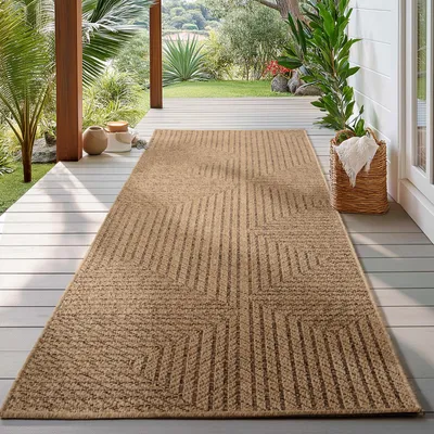 A rug is placed on a wooden deck outdoors, with plants and a basket in the background.