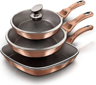 A set of three rose gold colored frying pans, stacked on top of each other, with one pan having a glass lid.