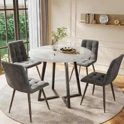 A round dining table with four chairs in a dining room setting.