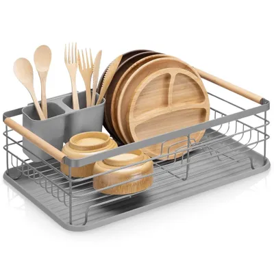 A dish drying rack filled with plates, bowls, and cutlery on a white background.