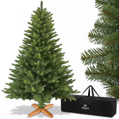 A green artificial Christmas tree with a wooden stand and a black storage bag.