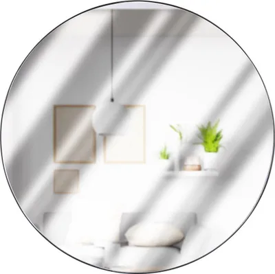 A round mirror reflecting a bright, modern living room with framed pictures and plants.