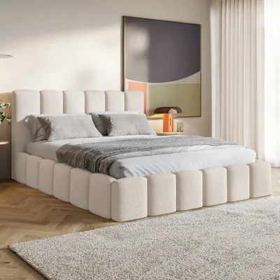 A bedroom scene with a bed, rug, and artwork.