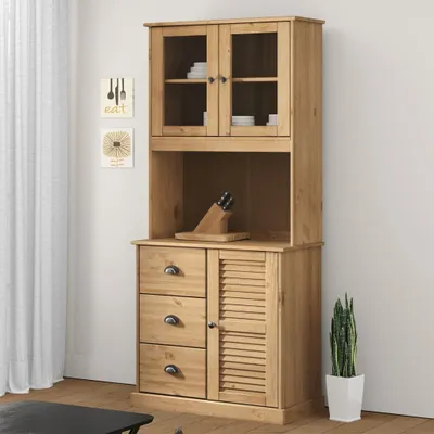 A wooden hutch with glass doors and drawers, standing against a white wall.