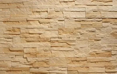 A close-up, full-frame view of a beige stone wall.