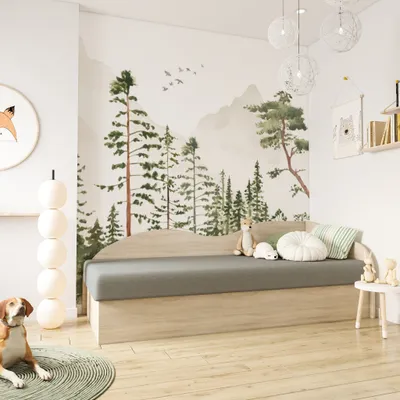 A child's bedroom with a forest-themed mural and a bed.
