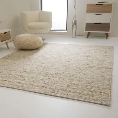 A minimalist living room scene with a rug, chair, and dresser.