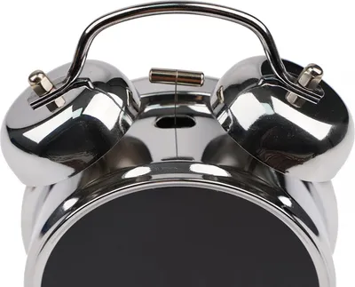 Close-up of the top part of a silver alarm clock with two bells.