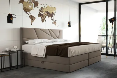 A bedroom with a large bed, a world map on the wall, and a window overlooking a balcony.