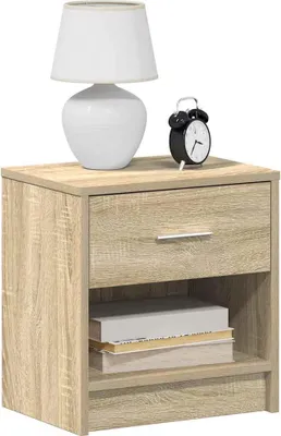 A wooden nightstand with a drawer and an open shelf, topped with a white lamp and a black alarm clock.