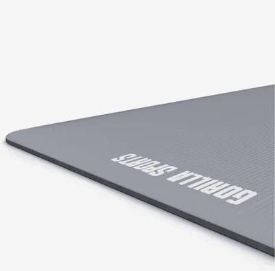 A close-up, angled view of a gray yoga mat with the brand name printed on it.