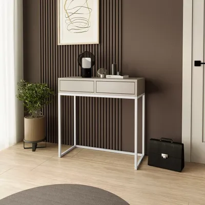 A console table with two drawers is placed against a wall with vertical wooden slats. A plant is to the left, and a briefcase is to the right.