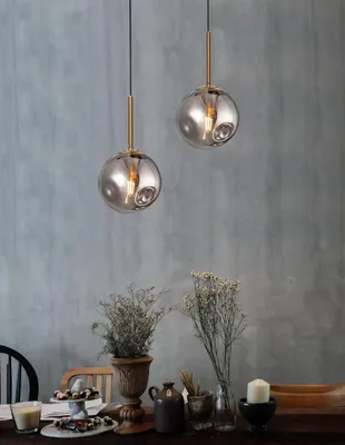 Two pendant lights hang above a table set with decorative items and food.
